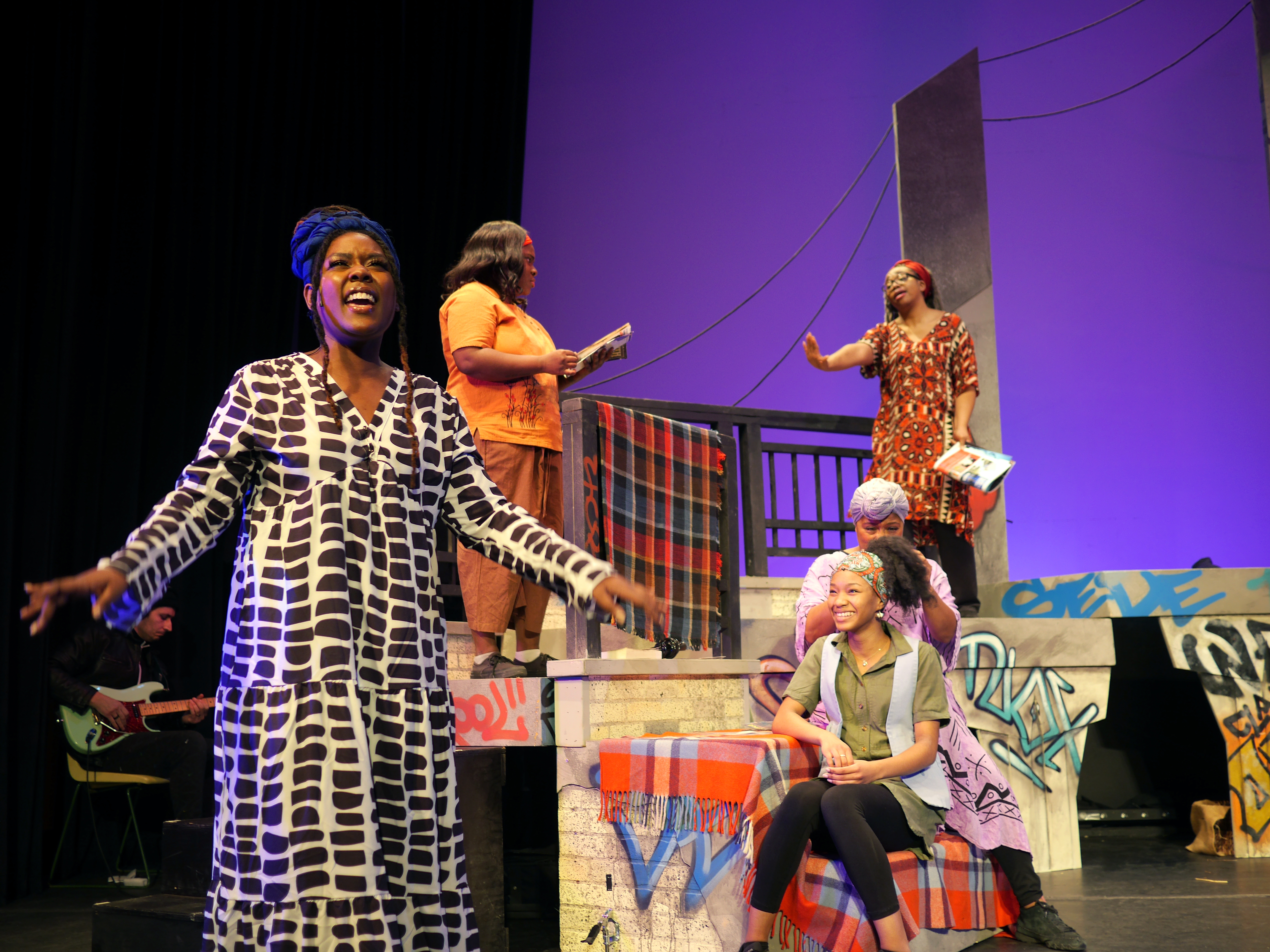 Image of female performer singing on a theater stage.